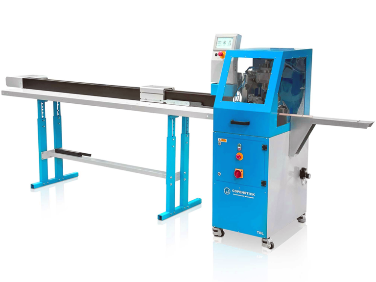 Copenstick TDL industrial machine in blue with a long feed rail, conveyor belt, touchscreen panel and red control buttons