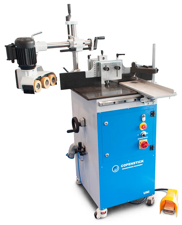 Copenstick UNI woodworking spindle moulder machine with blue cabinet, motor, feed rollers and spindle speed control panel