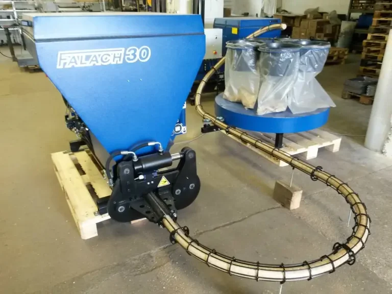 Falach 30 briquette machine in blue, mounted on a wooden pallet with hydraulic fittings and a flexible hose in a workshop
