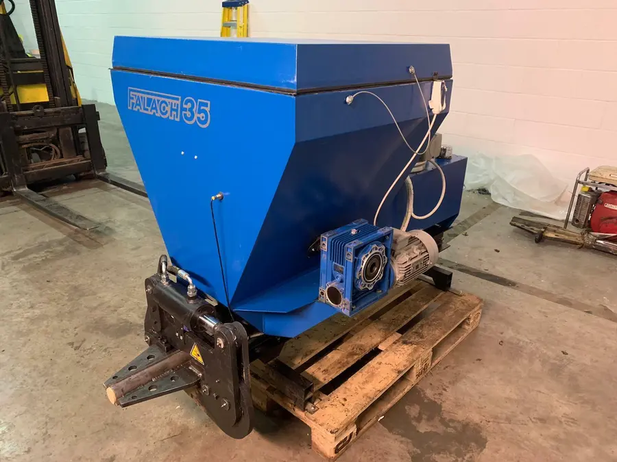 Falach 35 briquette machine in blue, mounted on a wooden pallet with a gearbox motor, inside an industrial workshop
