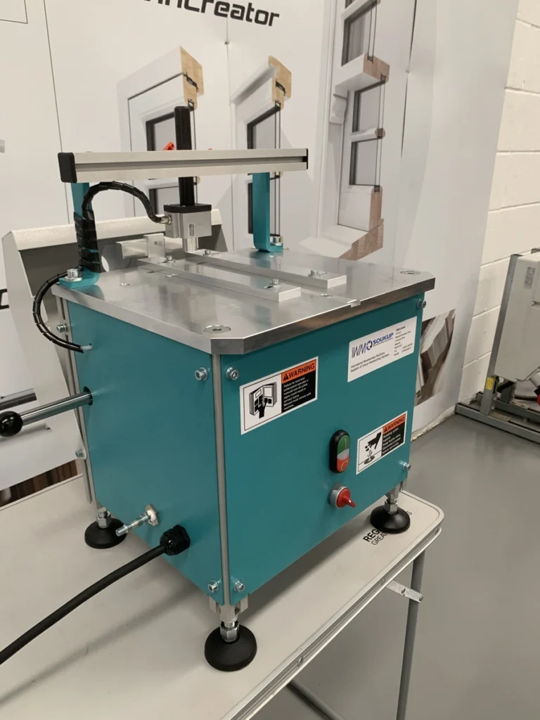 Teal WMO Soukup HEP glazing bead end profile scribing machine on a workbench with warning labels and control buttons