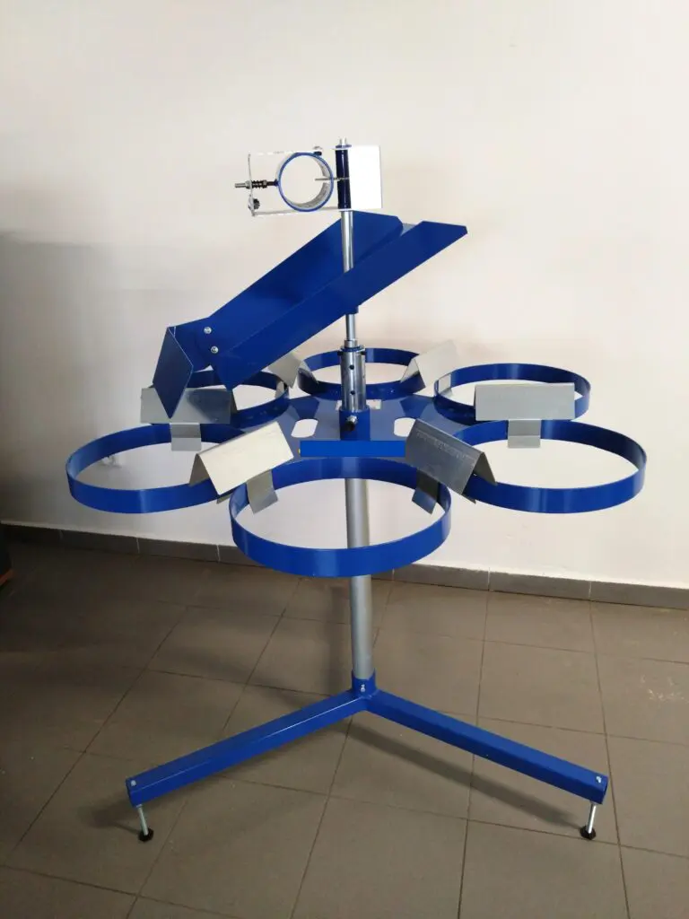 Blue metal IWM six bag carousel unit with top loading tray, featuring six circular ring holders on a central pole and tripod base.