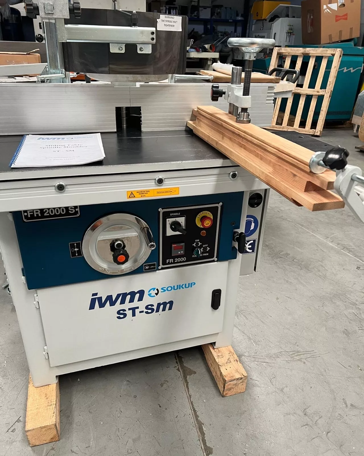 IWM Soukup ST-SM FR 2000 S sliding table spindle moulder with timber lengths resting on the table in a workshop