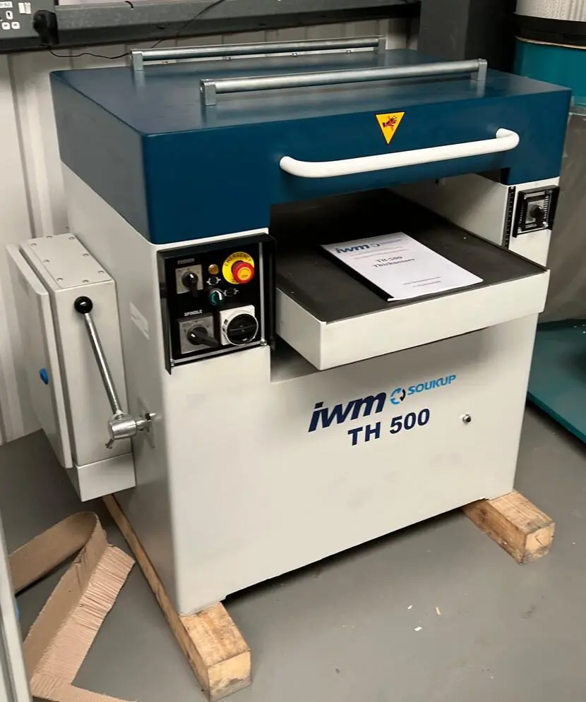 IWM Soukup TH 500 thicknesser machine with blue hood, control panel, and instruction manual resting on wooden pallets